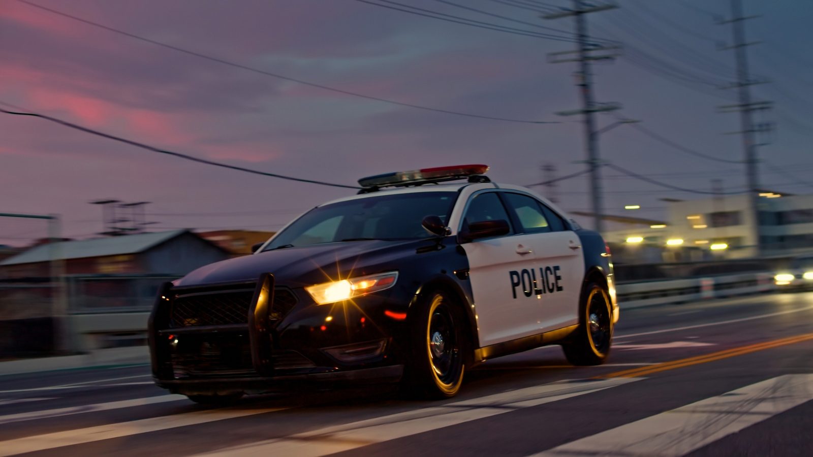 Police patrol car driving at dusk