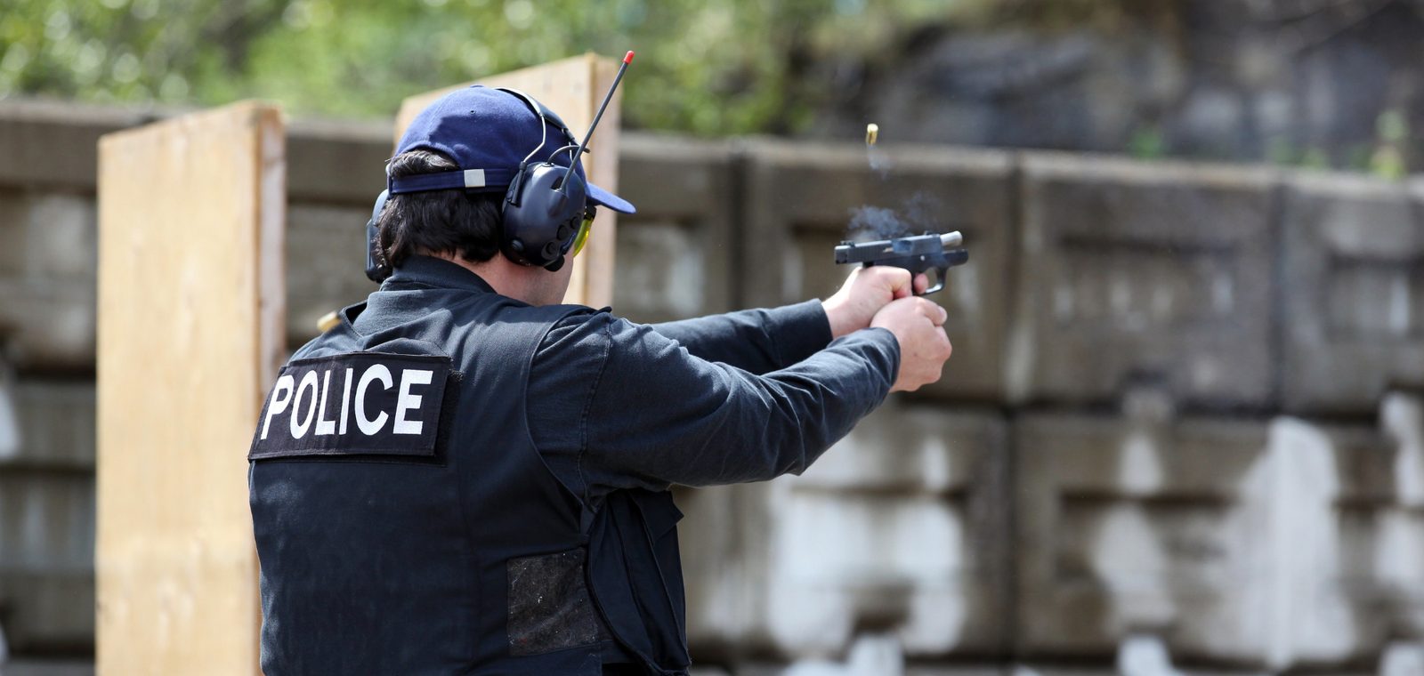 Police officer firing a handgun during range training